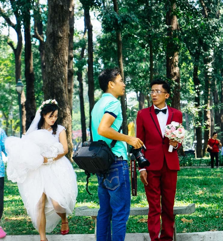 A wedding photographer, discussing a photo shoot with a bride and groom in Saigon Vienna