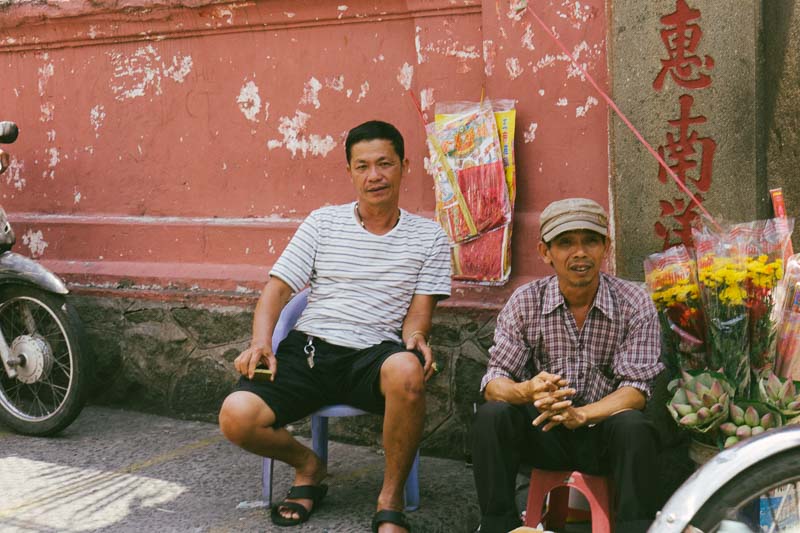 Two men on the side of the road selling flowers, Saigon Vietnam