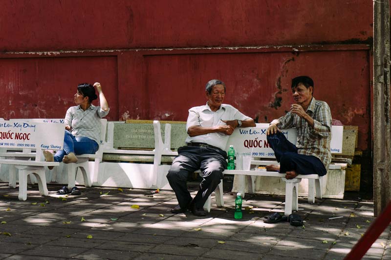 Two men on a bench, having a discussion in Saigon Vietnam
