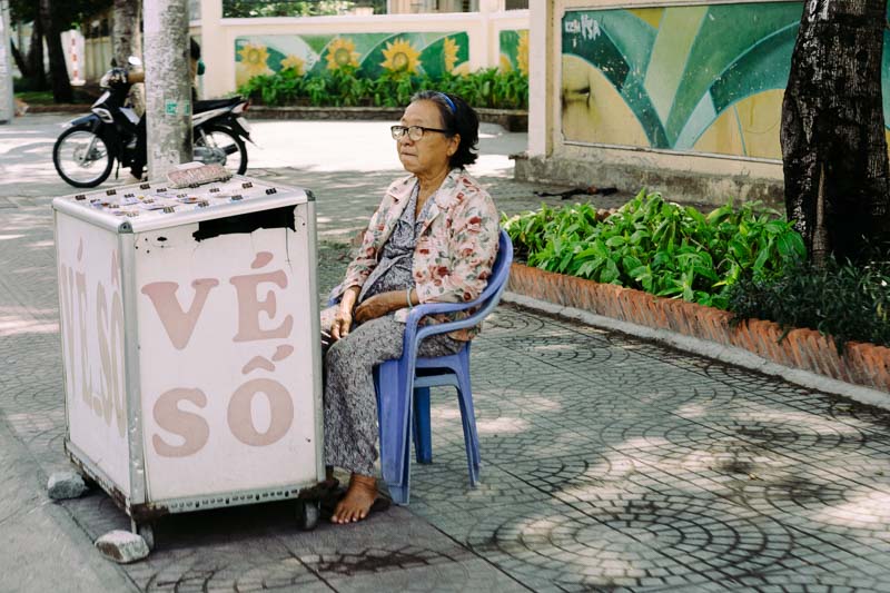 A picture of a woman with a ice cream stand in Saigon Viet