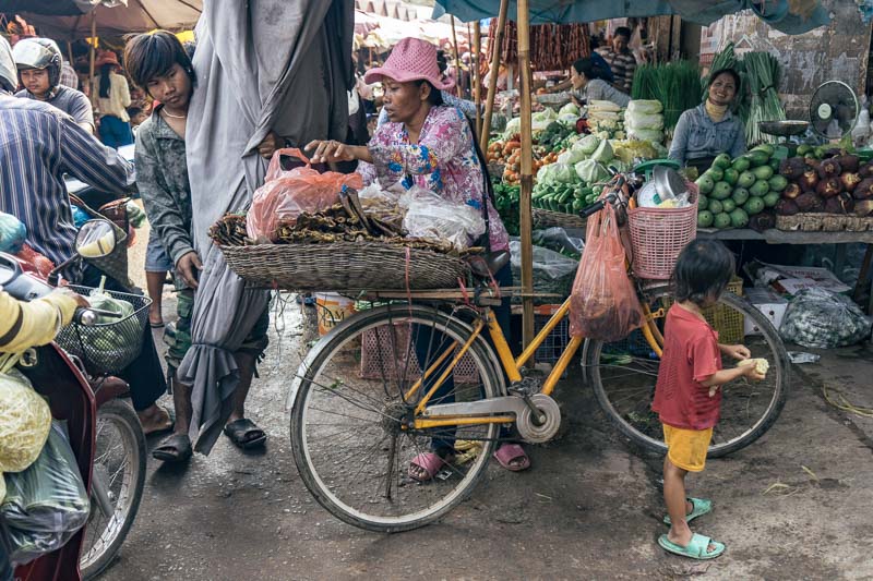 A market with a woman and her bike and her child in Angkor Wat Cambodia