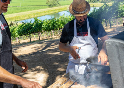 A photo of Dino from Diavola and Jake Hawkes from Hawkes wine at red winery. Vineyard cooking up sausages.